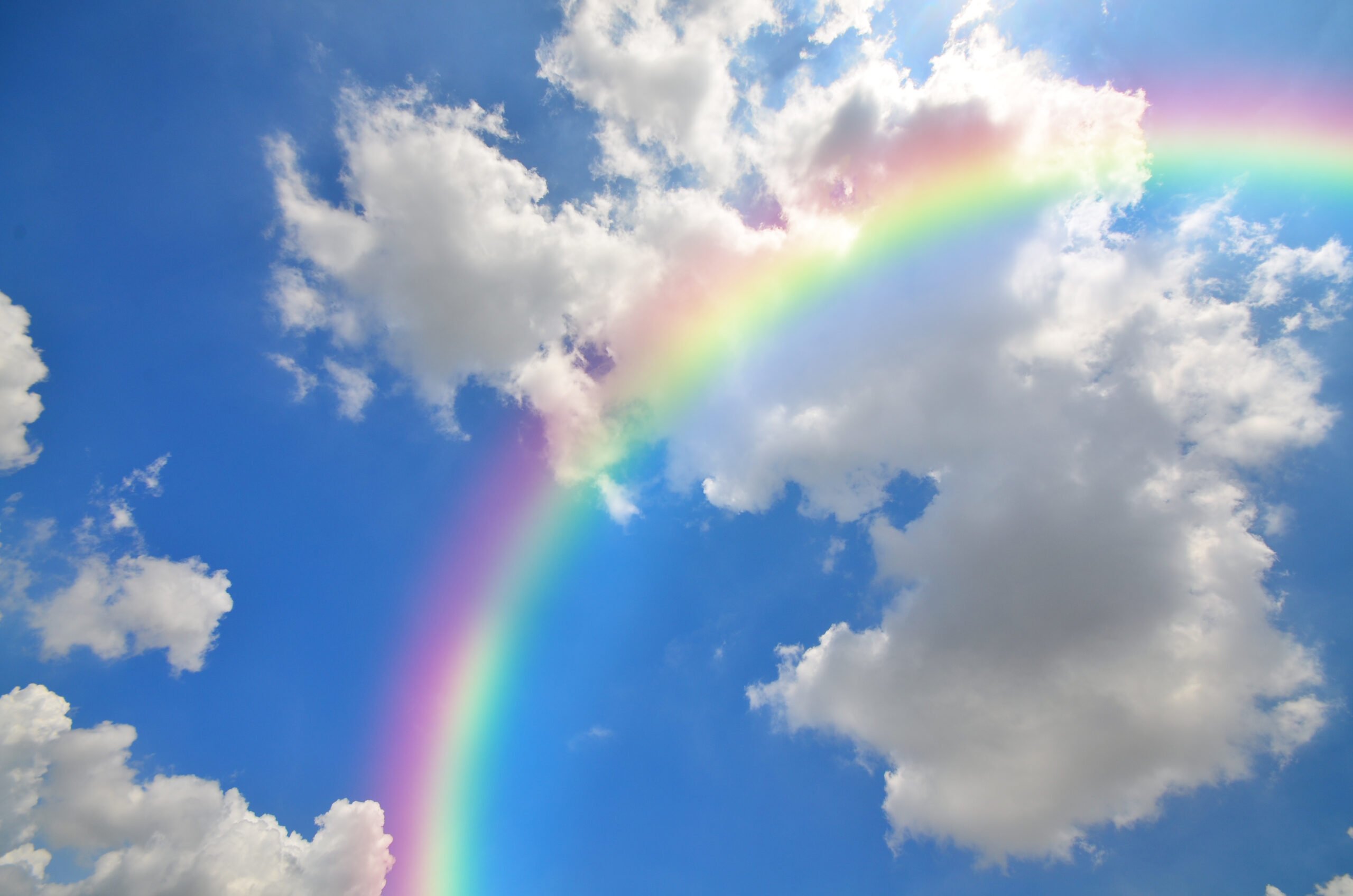 Rainbow and White clouds in blue sky background